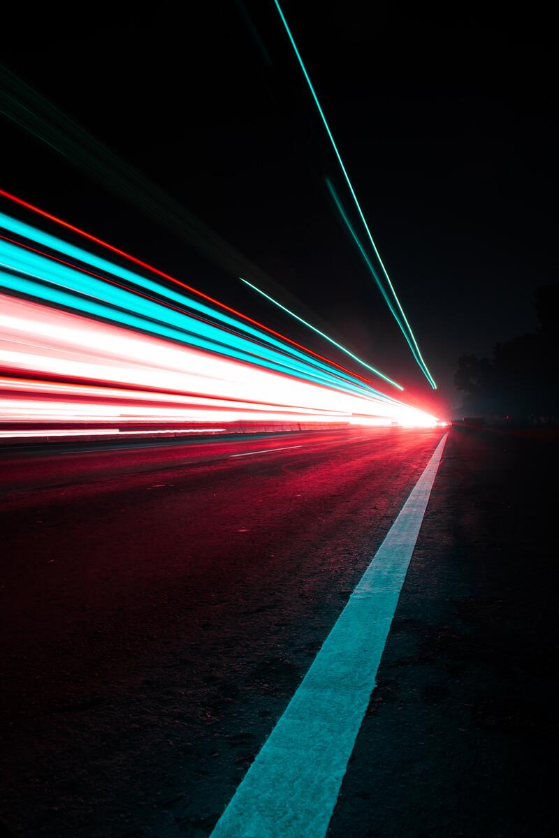 Light traces from cars, leading into the distance along a car road